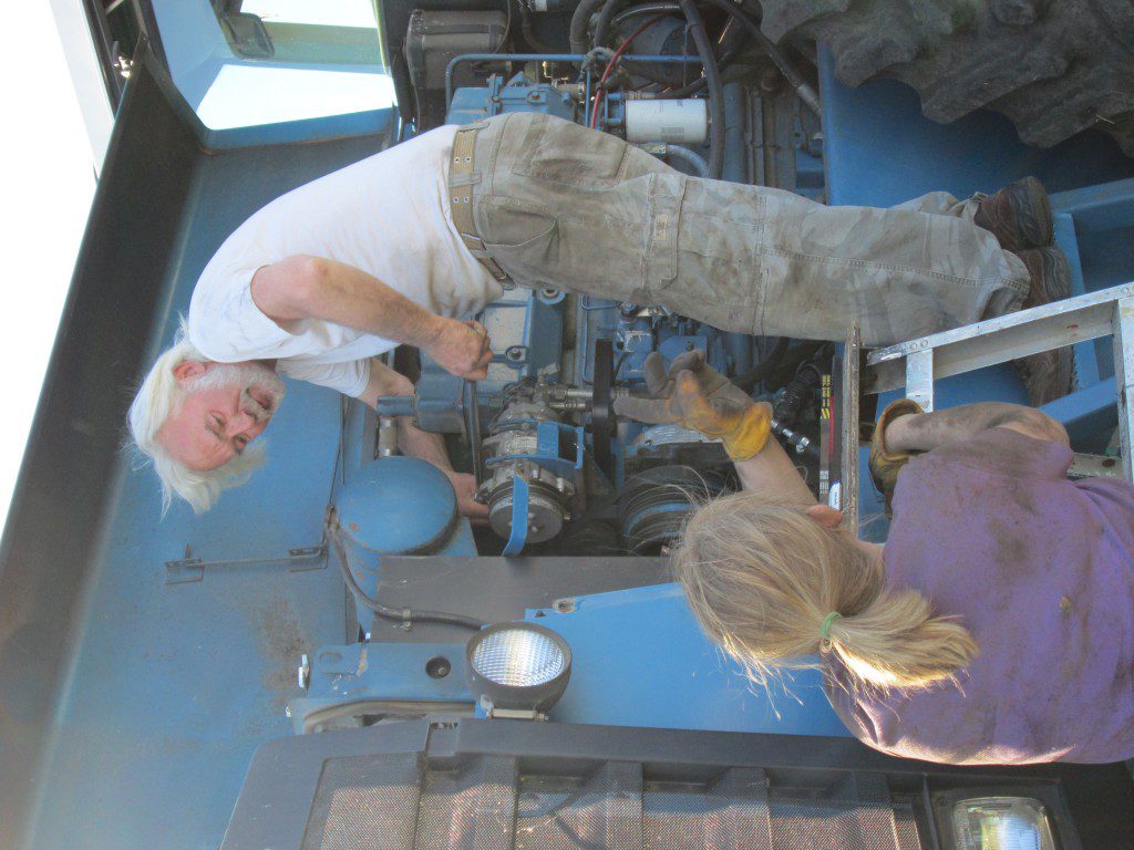 Mom and Bill changing the belts on Big Blue...