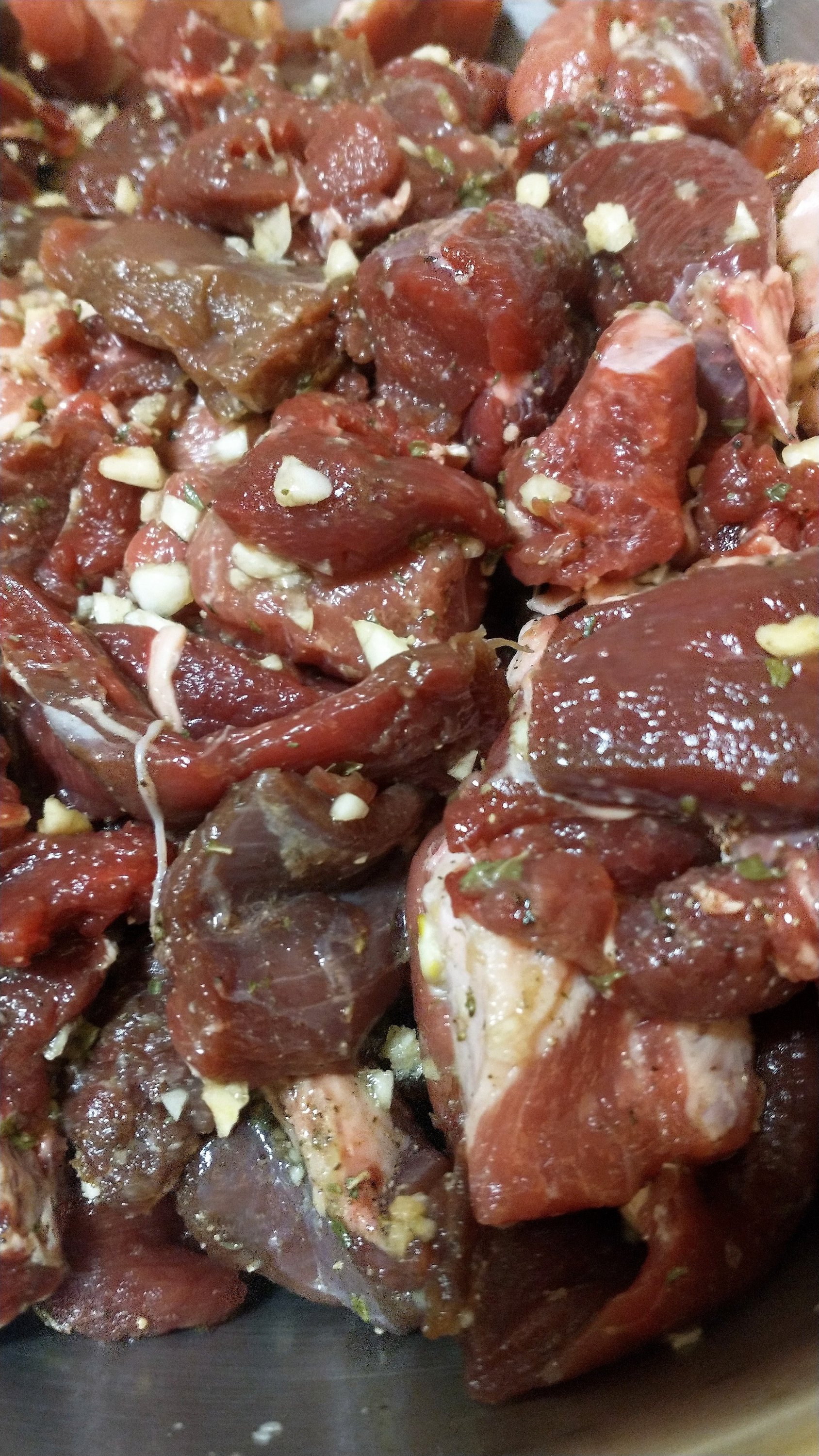 a bowl of cubed venison, pork shoulder, and seasonings for sausage.