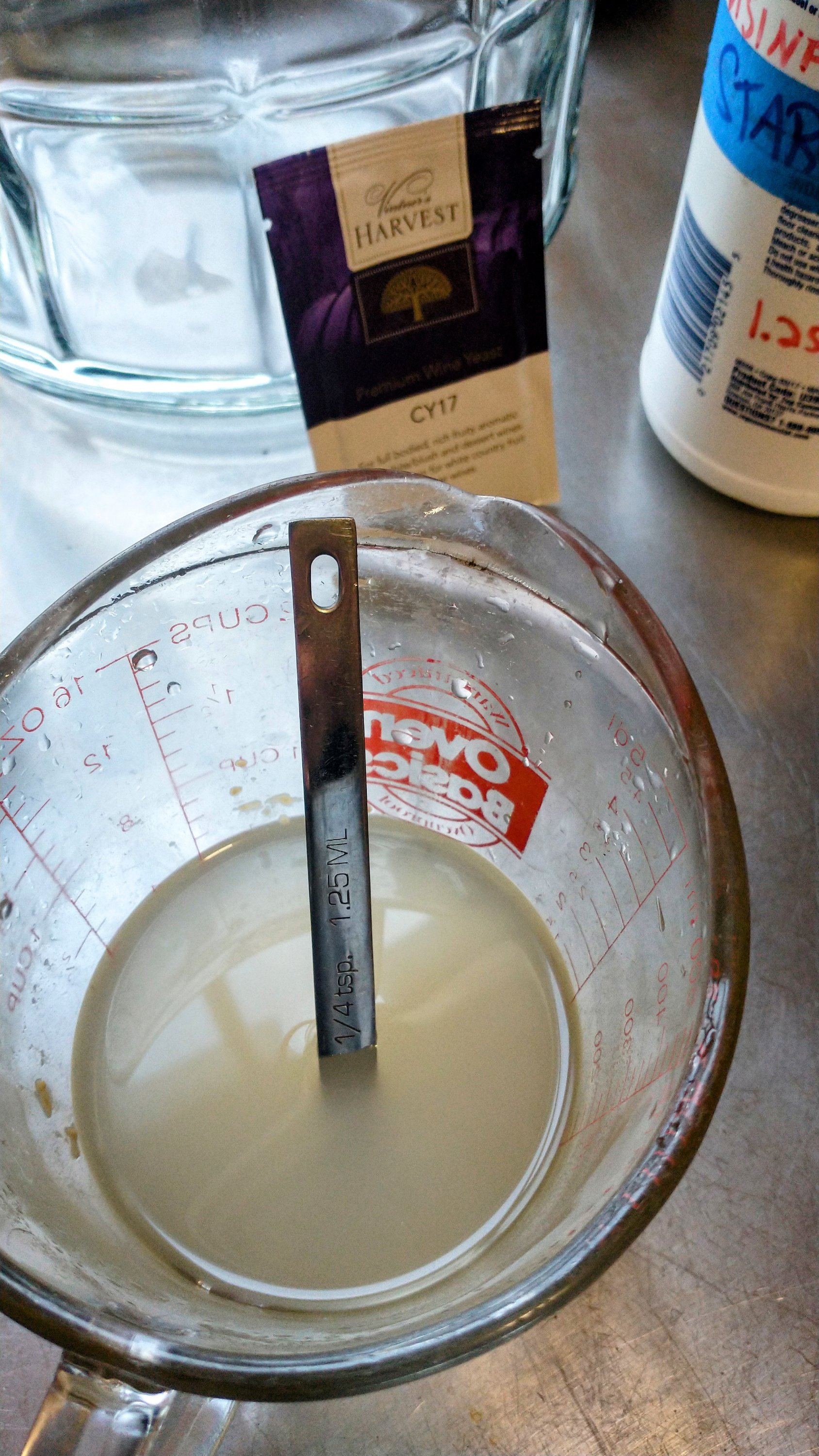 a measuring cup with yeast starter and a packet of brewing yeast.