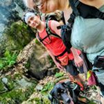 Backpacking selfie of the author, her partner, and their dog in front of a rocky outcropping in the Upper Peninsula of Michigan.