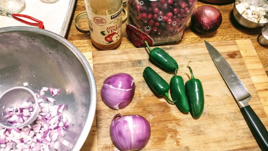 chopping and prepping red onion, jalapeno peppers, and cranberries for fruit salsa.