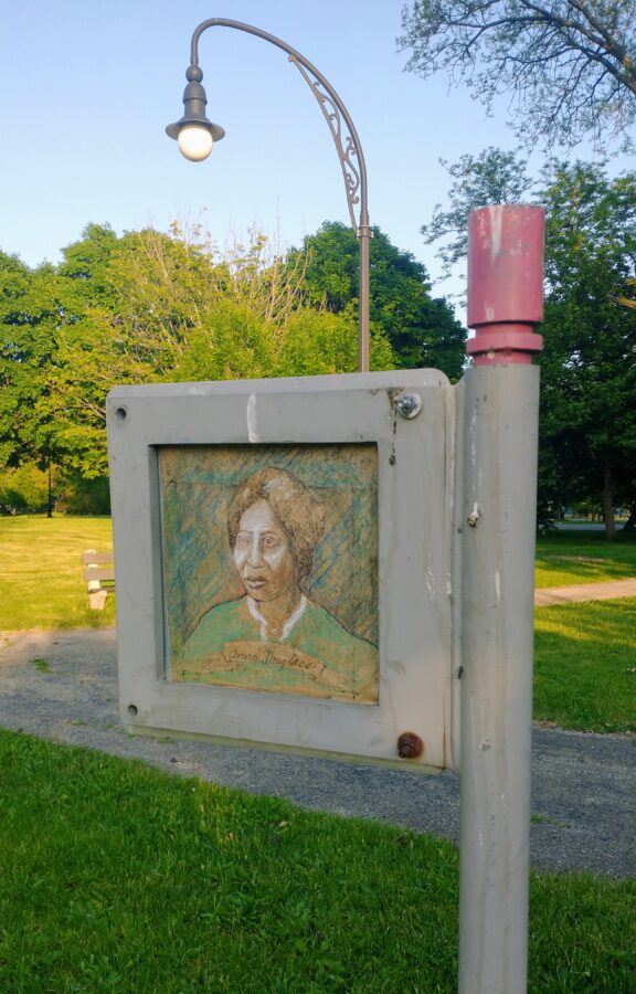 A hand-drawn portrait of Anna Douglass installed on the back of a Chicago park sign