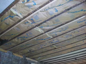 paper-backed fiberglass insulation installed on a ceiling between exposed joists