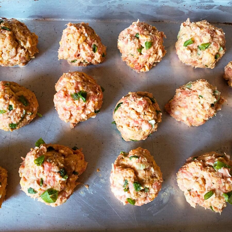 southern sausage and cheese balls shaped and spread out on a sheet pan.