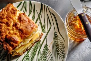 Sausage, cheese, and hot pepper jelly biscuit sandwich on a vintage "Americana" wheat pattern Homer Laughlin plate