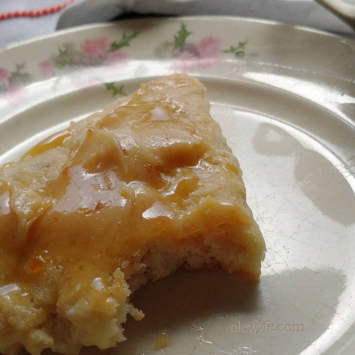 lemon oat scone on a plate with marmalade butter on top and a bite taken out of one corner.