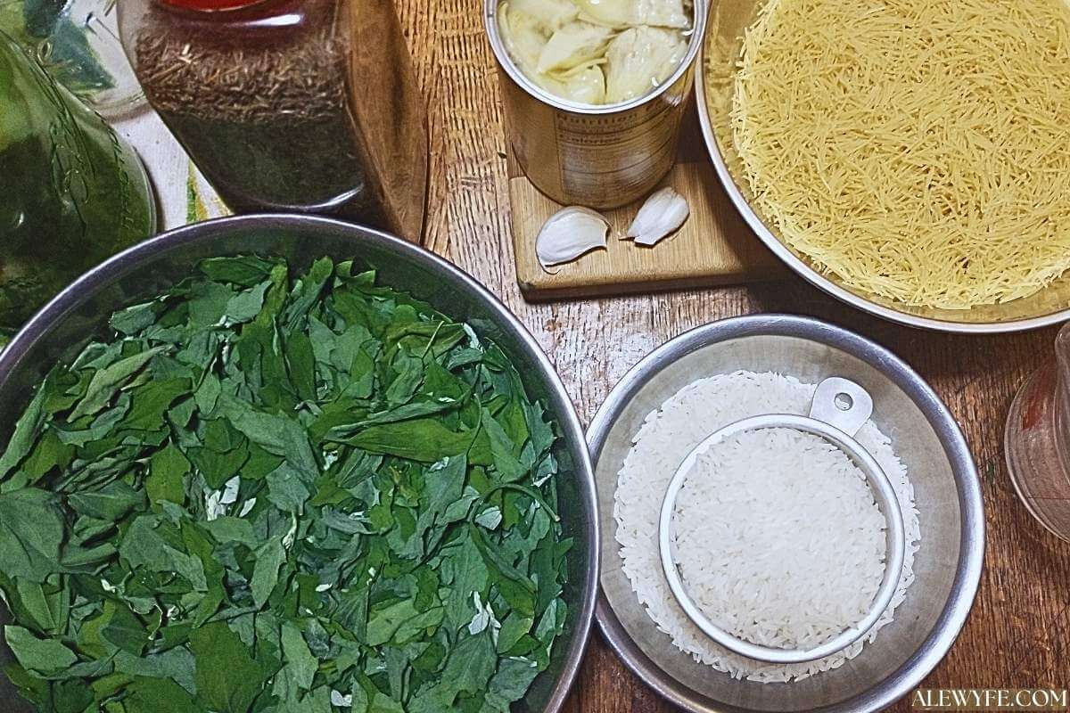 mise en place ingredients for lemon vermicelli rice pilaf (bowls of rice, vermicelli, greens, and herbs and a can of artichoke hearts).
