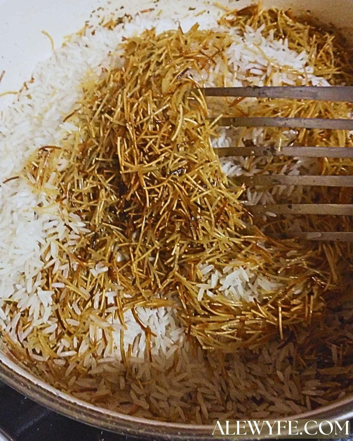adding the rice to the toasted vermicelli and stirring the pot.