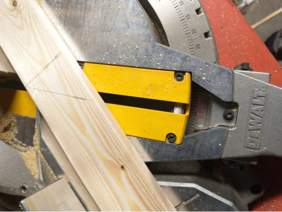 cutting the wooden frame pieces on an angle with a miter saw