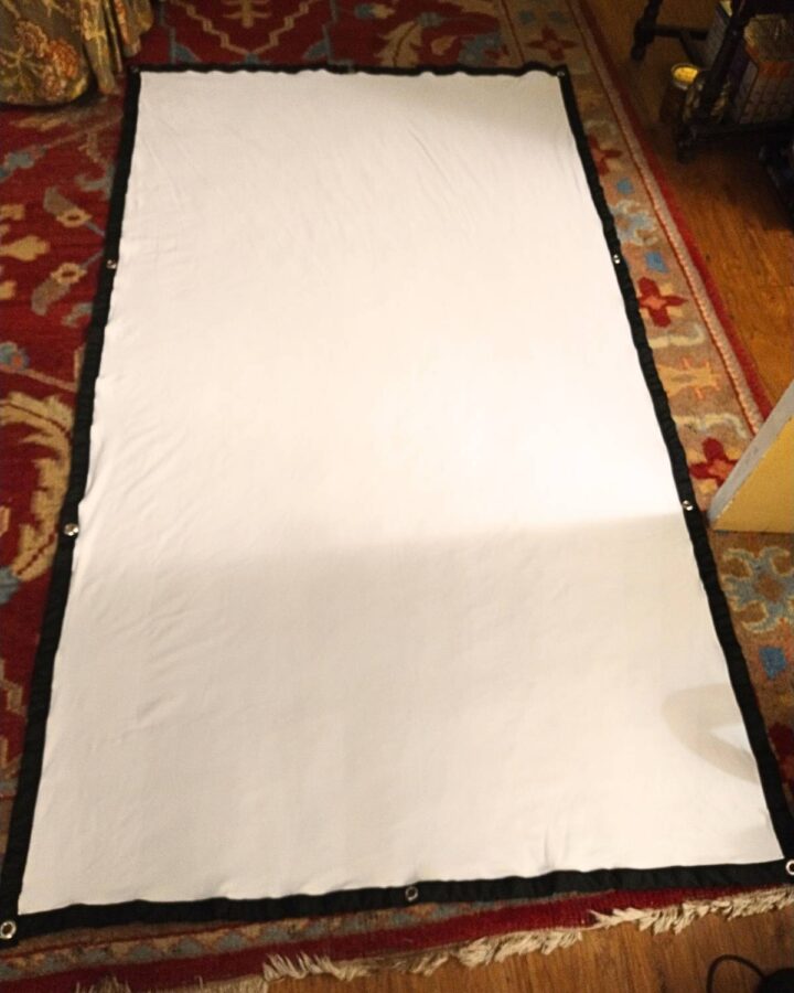 laying out the fabric projector screen on the living room rug to use as a template to make the frame