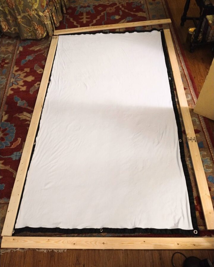 laying out the wooden frame pieces on the fabric screen to check dimensions and mark boards for cutting the miter joints for the corners