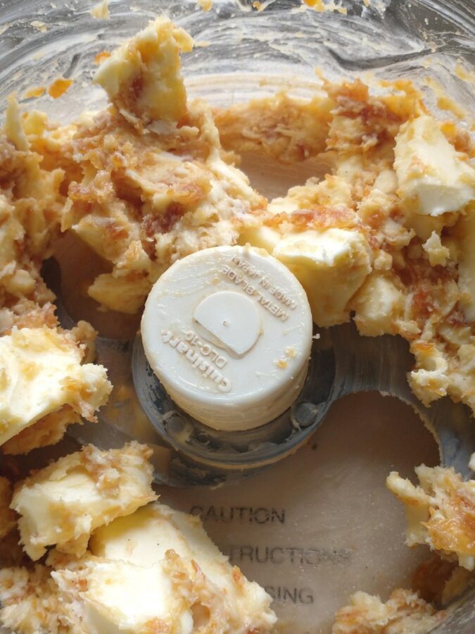 compound butter mixture beginning to come together, but chunks of butter remain visible