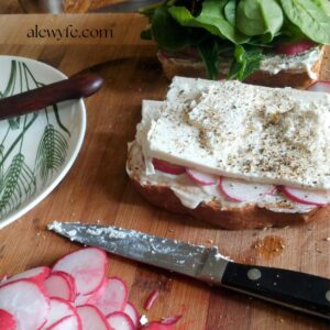 vegetarian sandwich being assembled on a cutting board
