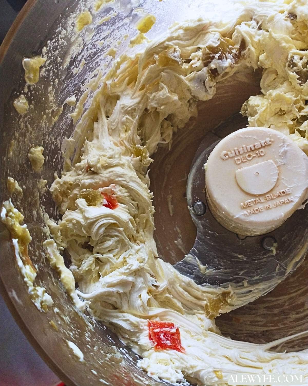 spicy pizza spread in a food processor, blending cream cheese with pizza toppings.