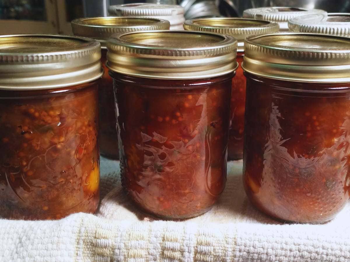 jars of pear chutney cooling on a kitchen towel