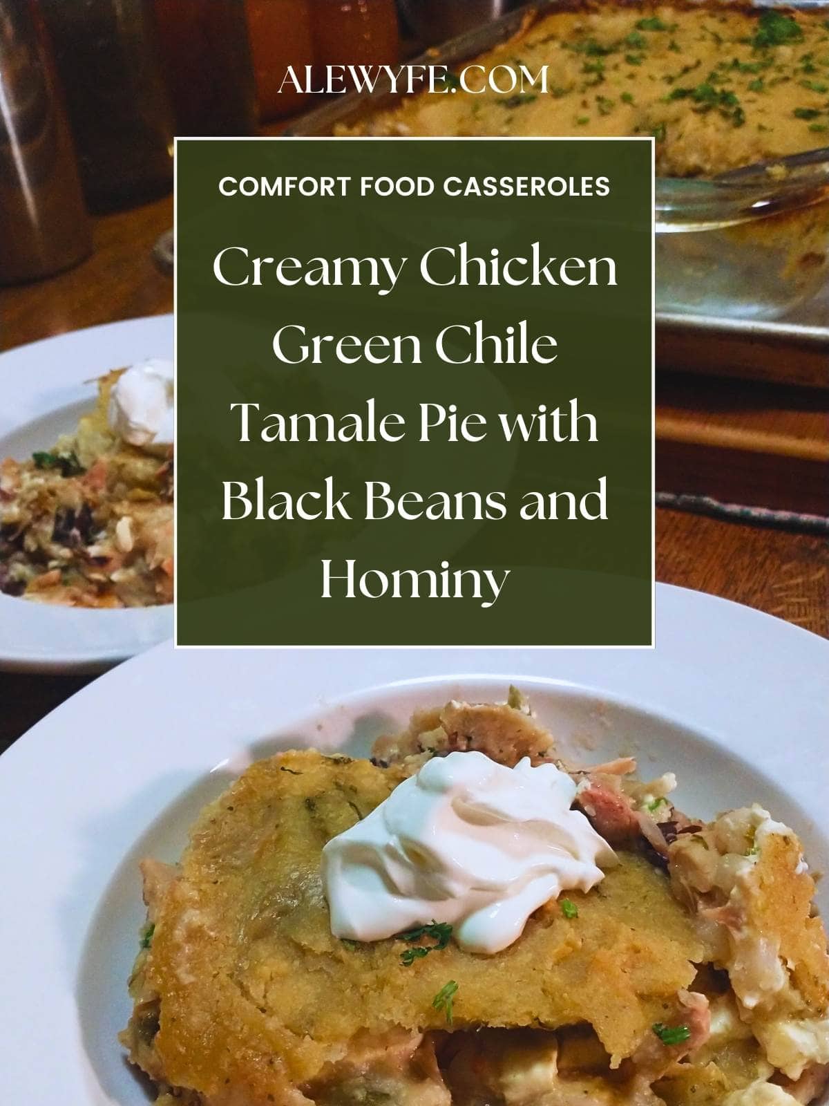 title image for post... two bowls of tamale pie topped with sour cream with a casserole dish in the background. text reads, "alewyfe.com comfort food casseroles creamy chicken green chile tamale pie with black beans and hominy"