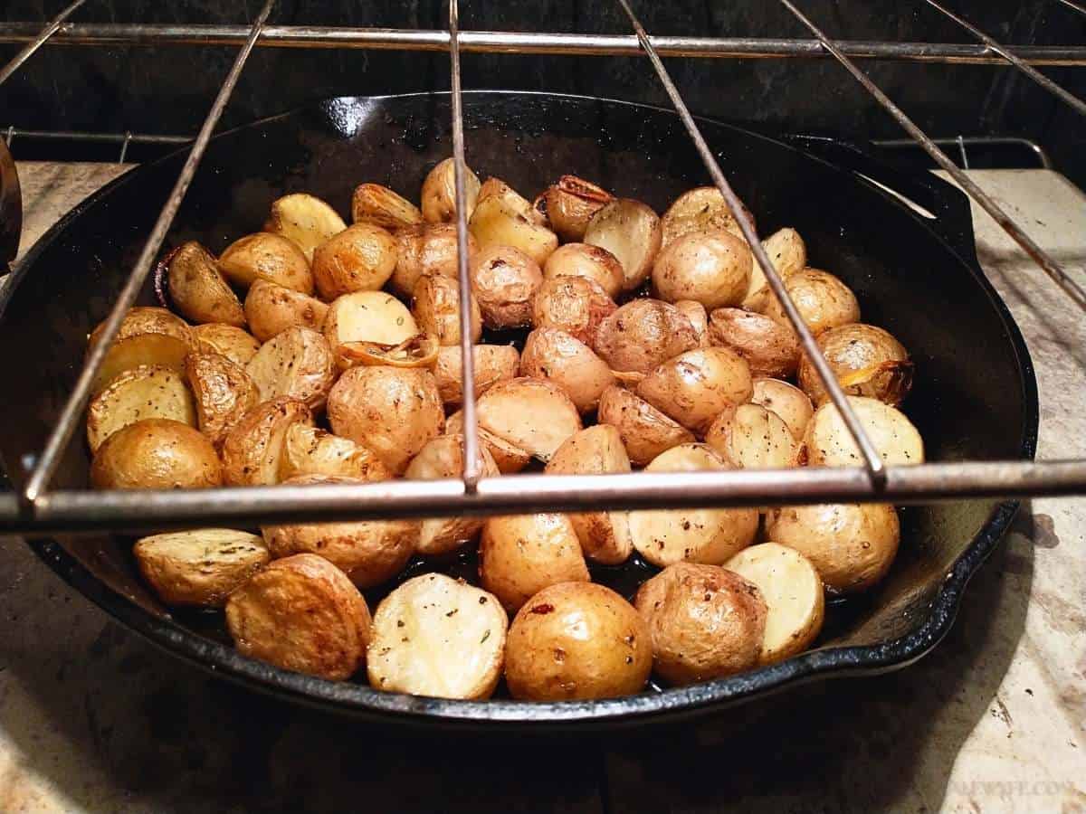 lemon herb new potatoes roasting in a cast iron pan on a baking stone in the oven