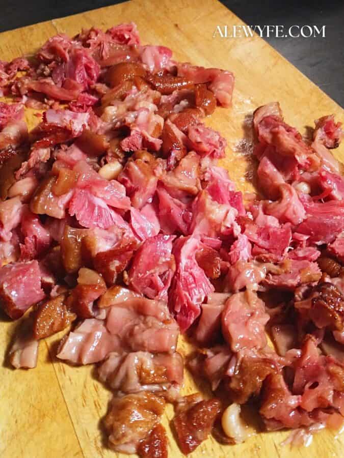 cooked and shredded smoked pork hock on a cutting board