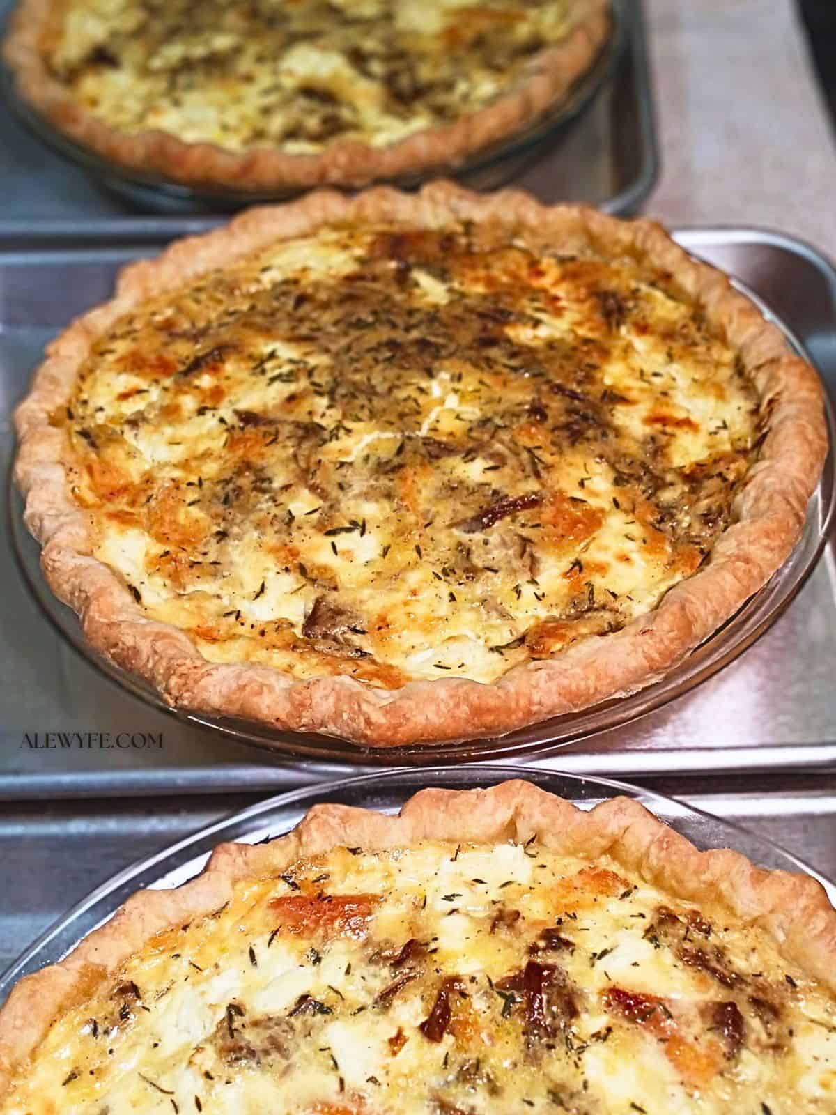 trio of baked butternut squash, goat cheese, and caramelized onion quiches lined up to cool on a table
