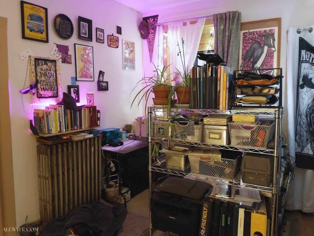 The new view of my desk from the kitchen and pantry doors... the desk is blocked by the tall shelf, and the sewing table is in the corner directly behind the desk. Bright colorful pink and white lights are lit up in the corner. 