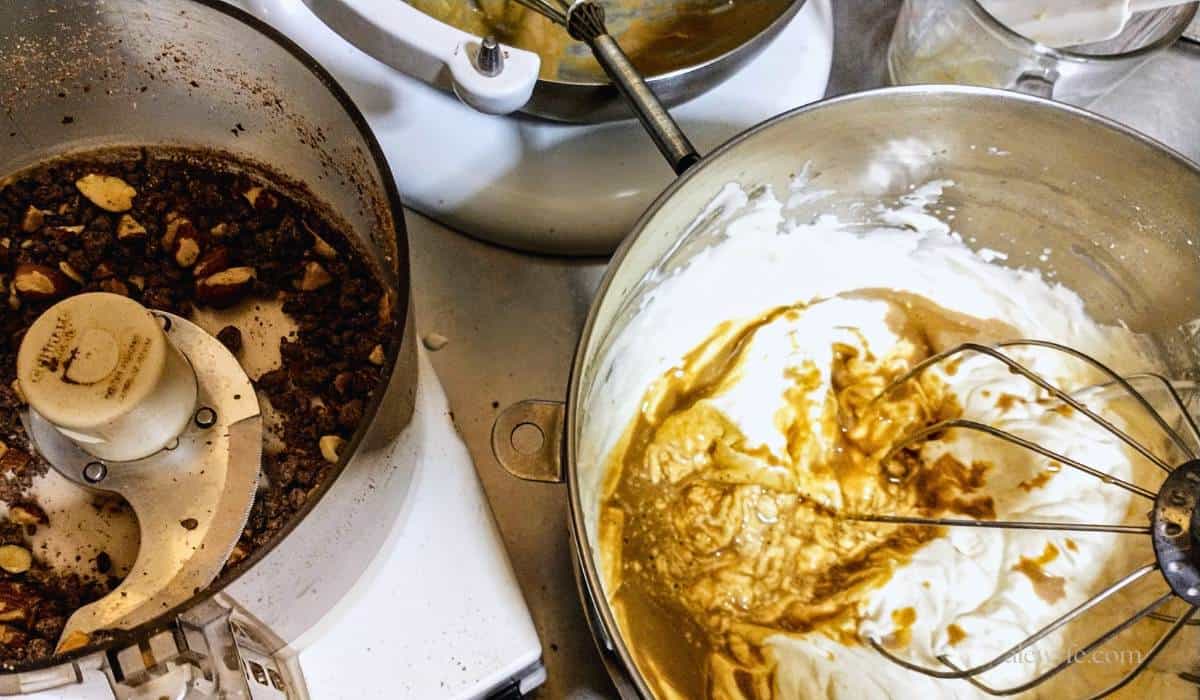 A mixer bowl of whipped cream & espresso, and a food processor with chopped chocolate smoked almond before folding everything together.