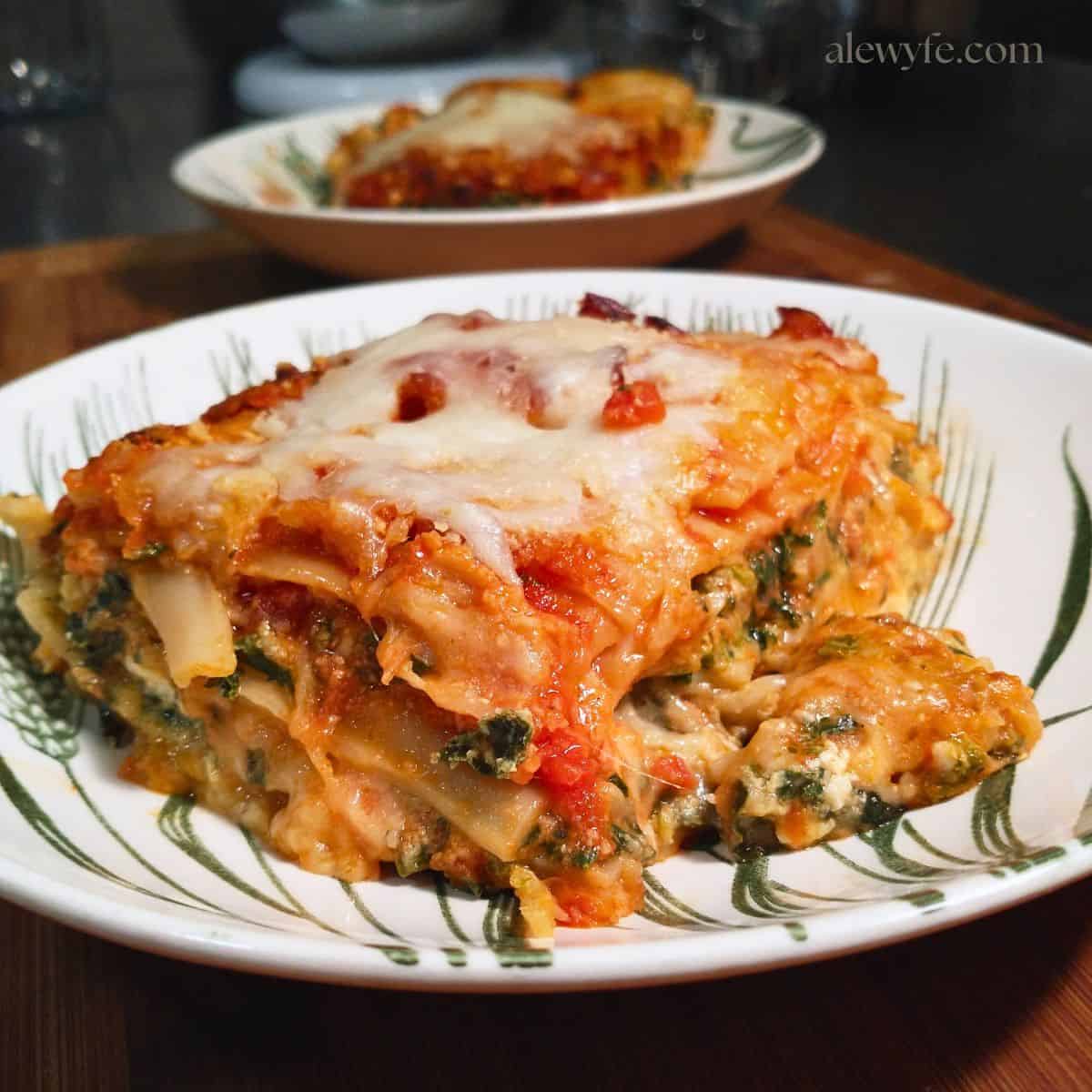 a plate with a large slice of homemade spinach and cheese lasagna.