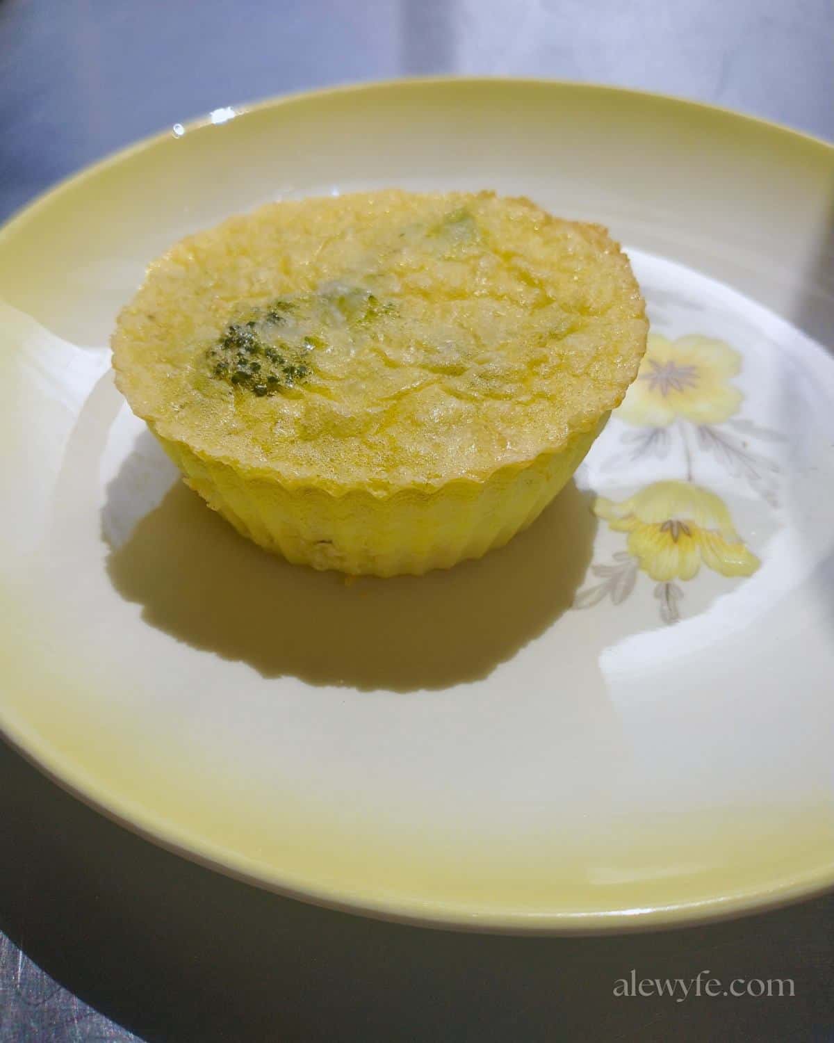a broccoli and cheese egg bite on a small plate.