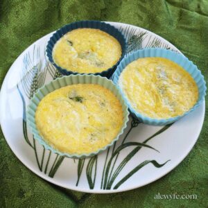 three spinach and artichoke egg muffins on a plate.