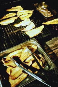 rainbow trout filets lightly smoking in an offset charcoal smoker.