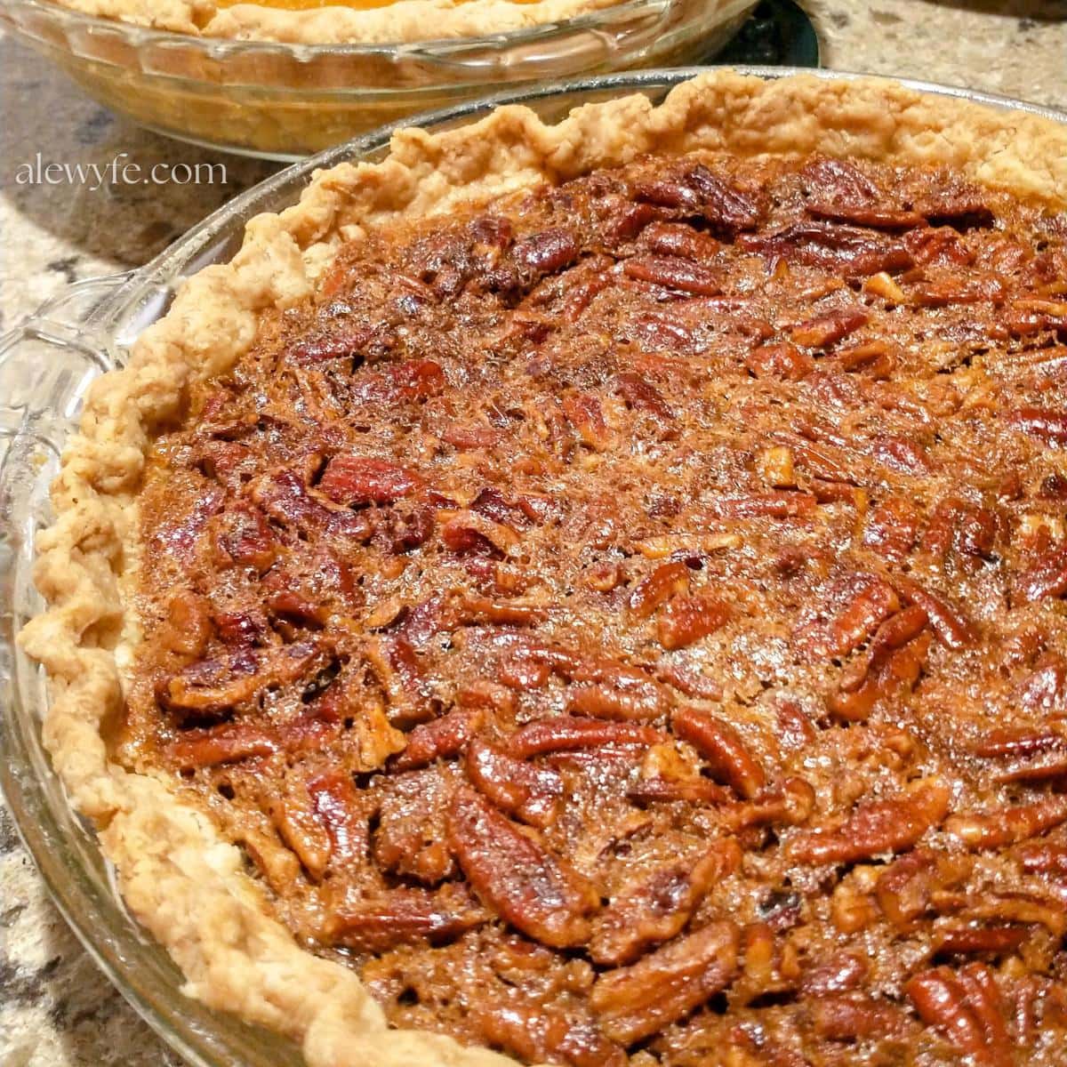 a homemade southern pecan pie cooling on a countertop.