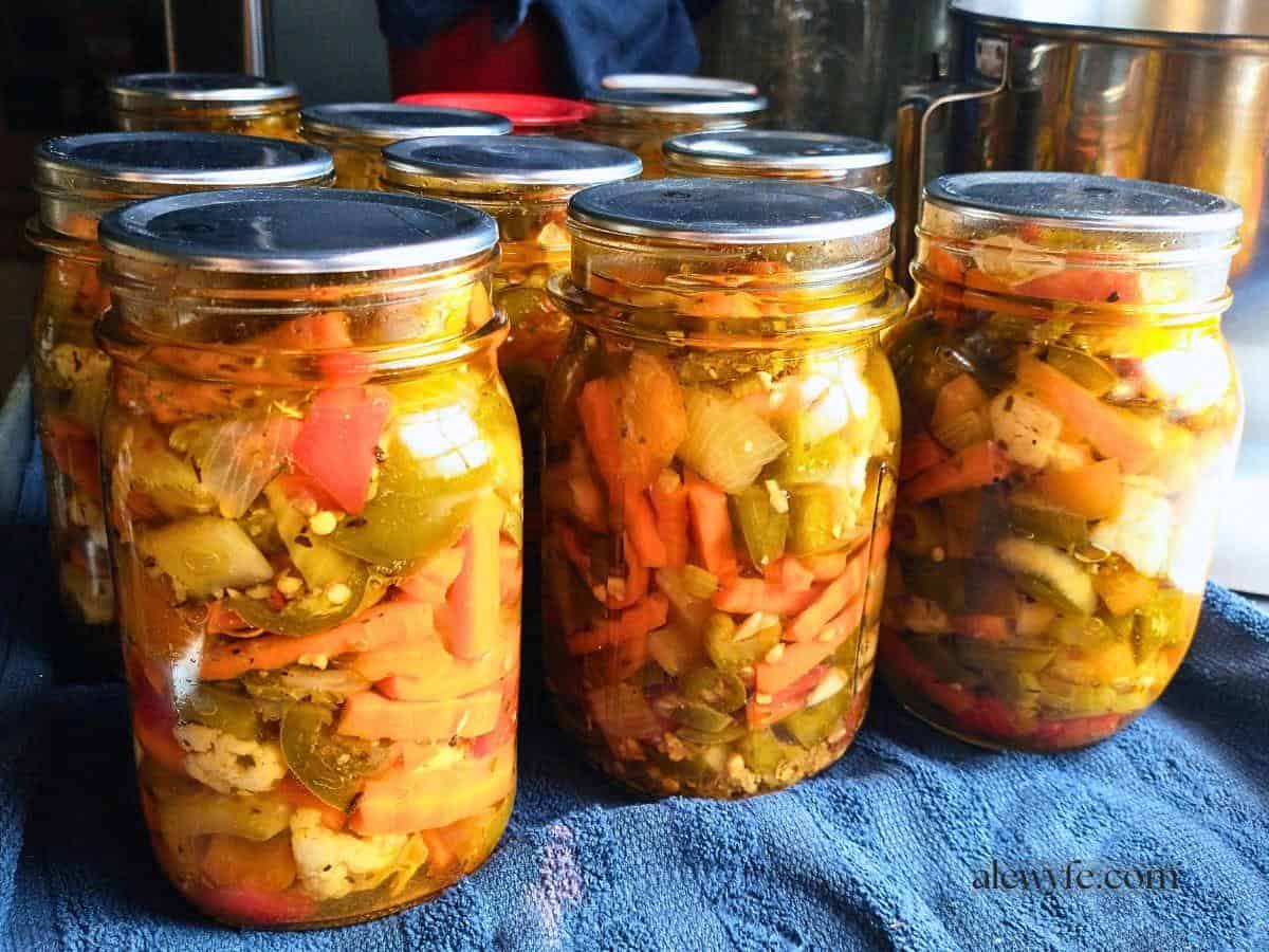jars of homemade chicago-style giardiniera sitting on a counter top.