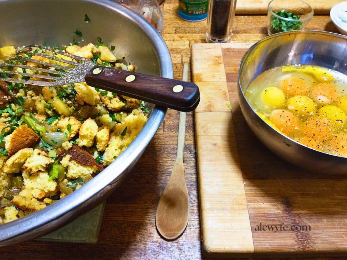 dressing recipe process shot showing cornbread cubes, sauteed vegetables, and a bowl of eggs. 