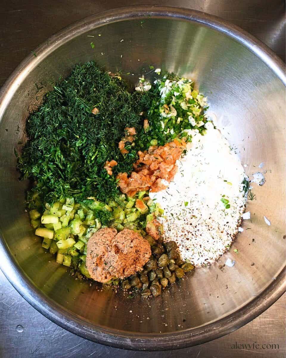 a mixing bowl filled with the dill yogurt dressing and chopped salad ingredients.