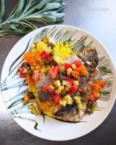 plated pan-seared trout with yellow rice and a fresh Mediterranean salsa, and a bundle of fresh garden sage.