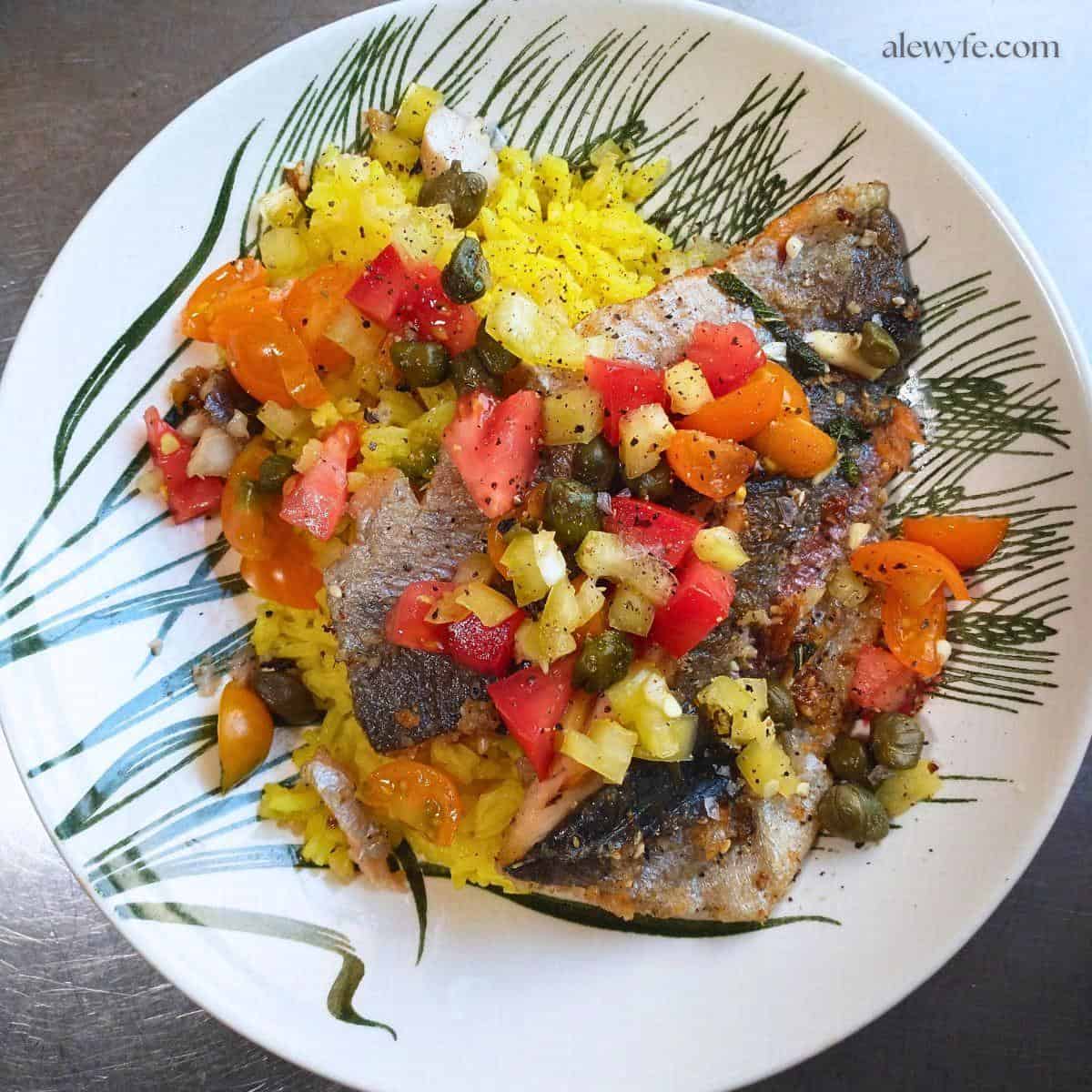 top down view of pan seared trout with tomato relish over yellow rice.