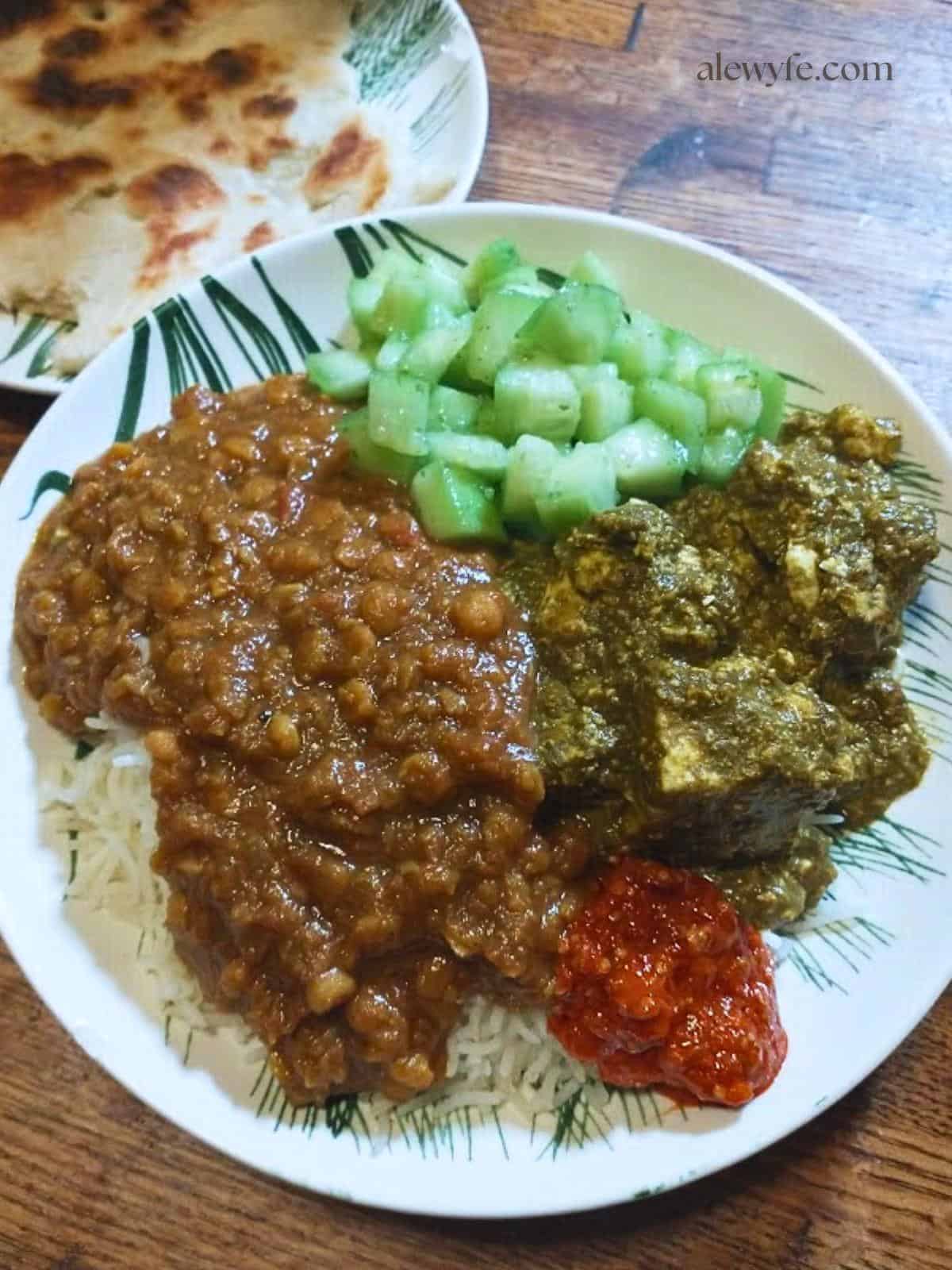 a plate with homemade Indian food including palak paneer and dal over rice.