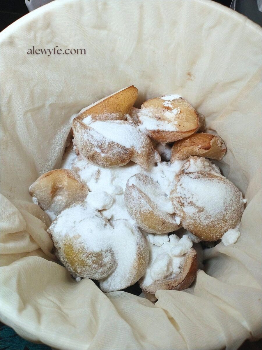 frozen pear halves and white sugar in a brewing bucket.