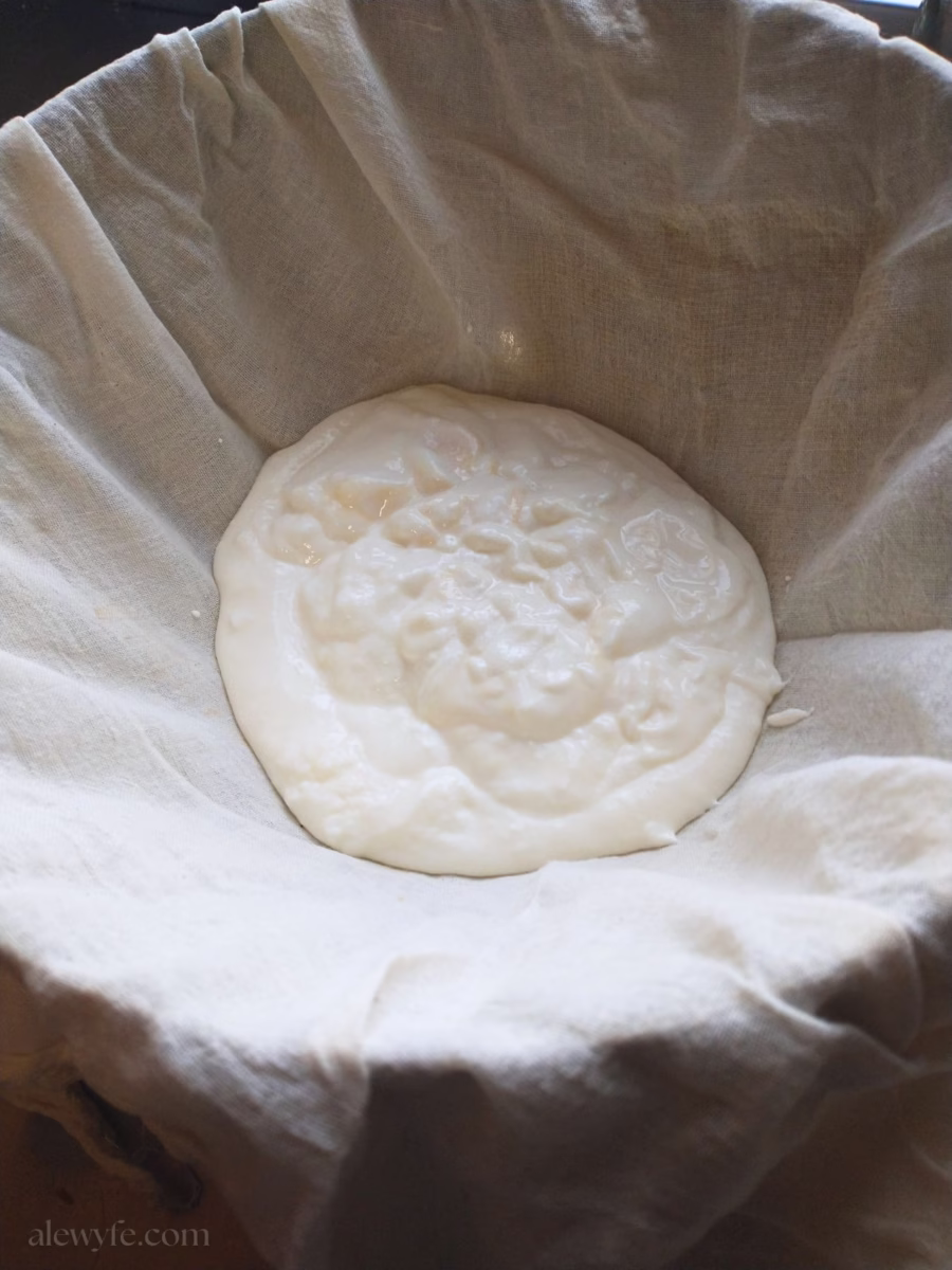a bowl lined with butter muslin filled with homemade yogurt.
