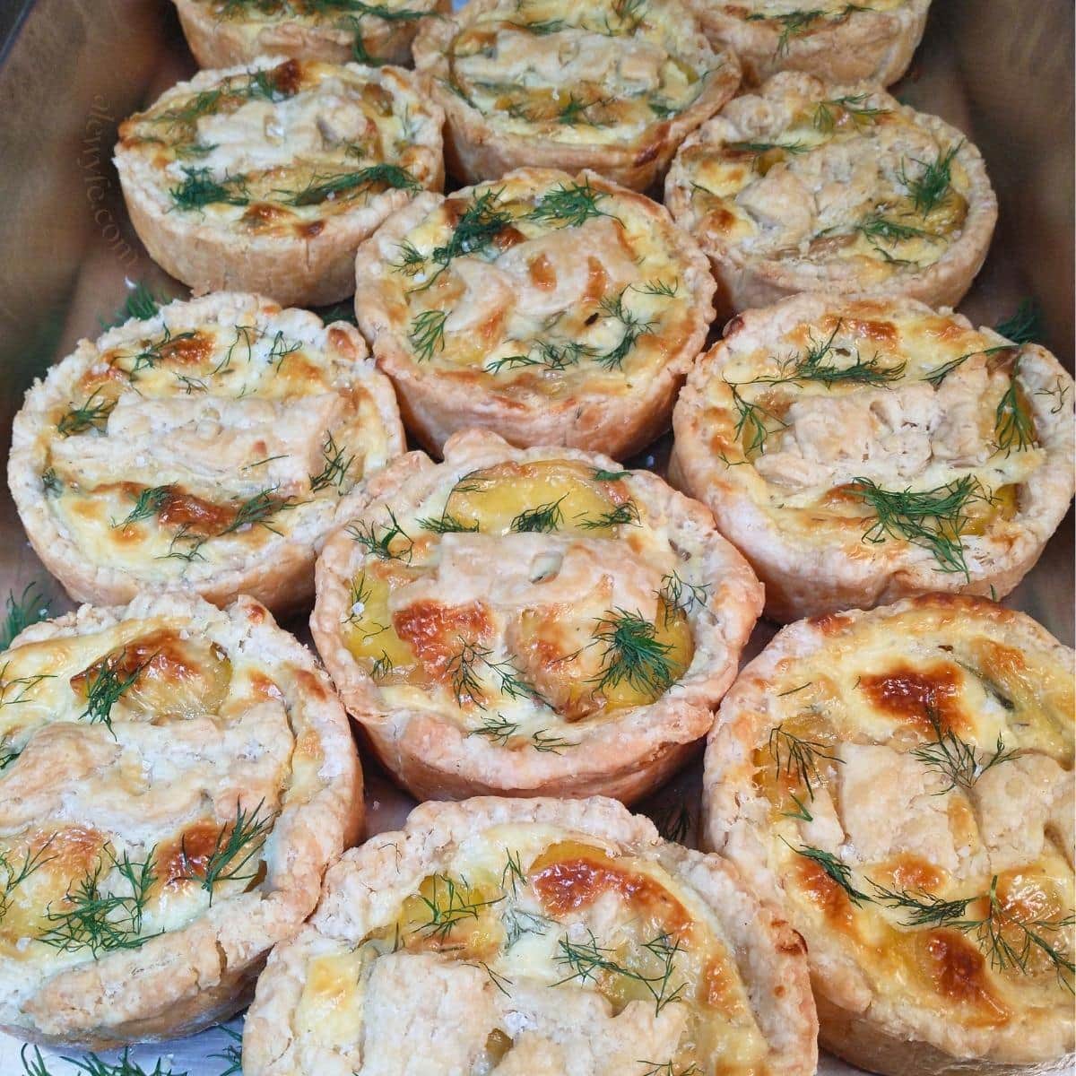 individual savory tartlets filled with yukon gold potato, goat cheese sauce, and fresh dill, in flaky pastry. The tarts have pastry cutouts that say "joy" baked on top of them.