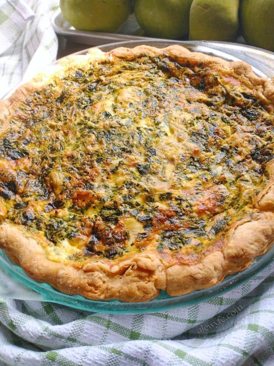 a freshly baked quiche with spinach, feta, and artichoke heart filling.