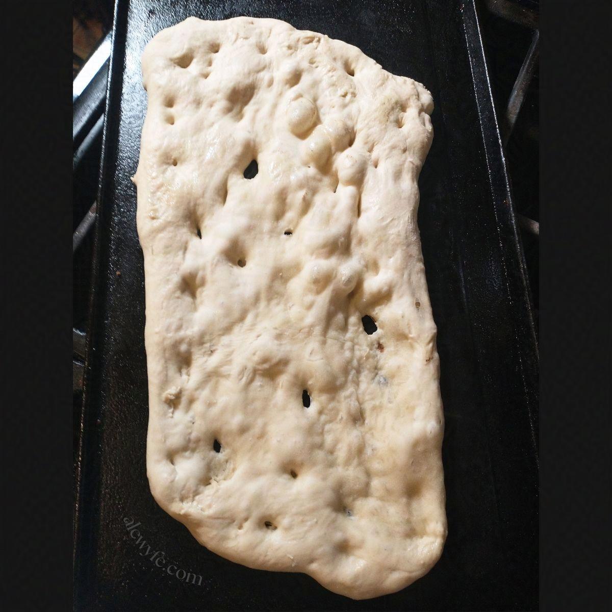buttermilk na'an cooking on a cast iron griddle.