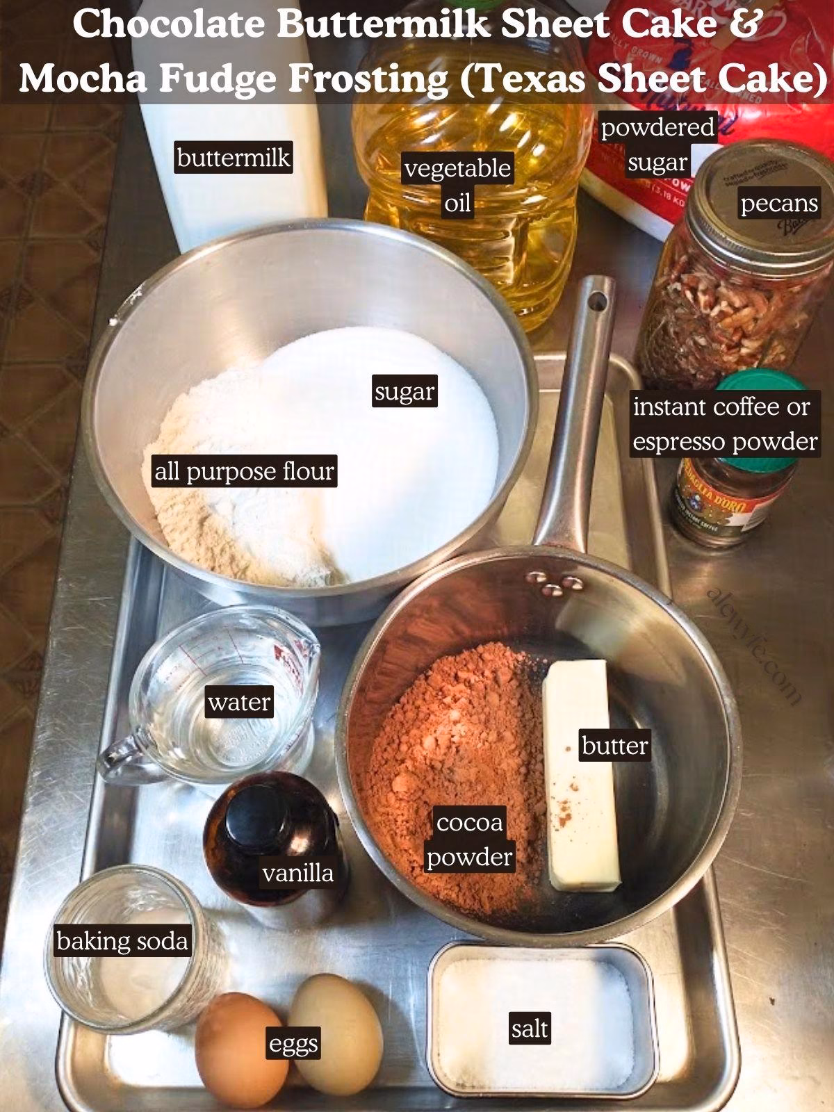 Labeled ingredient photo for Chocolate buttermilk sheet cake & mocha fudge frosting (texas sheet cake) recipe. Ingredients are laid out in bowls and measuring cups on a metal table and baking tray.